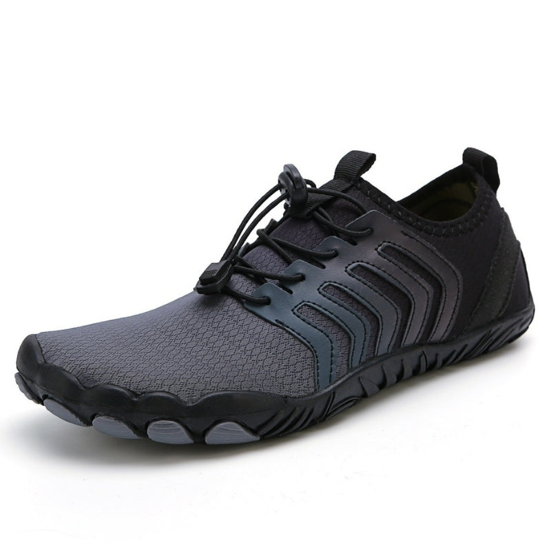 Grijze minimalistische hardloopschoen met zwarte accenten, lichtgewicht ontwerp en flexibele zool, ideaal voor trailrunning en fitness.