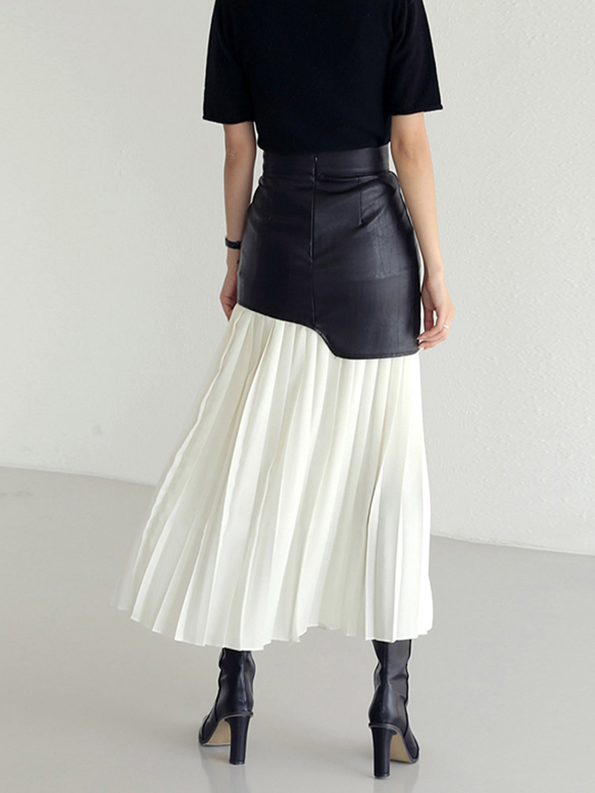Deze unieke rok combineert de stoere uitstraling van leer met de luchtige elegantie van chiffon, waardoor een opvallende en modieuze look ontstaat.