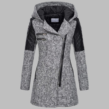 Grijze dames winterjas met capuchon, asymmetrische ritssluiting en zwarte leren accenten, ideaal voor koude weersomstandigheden en modieuze winterstijl.