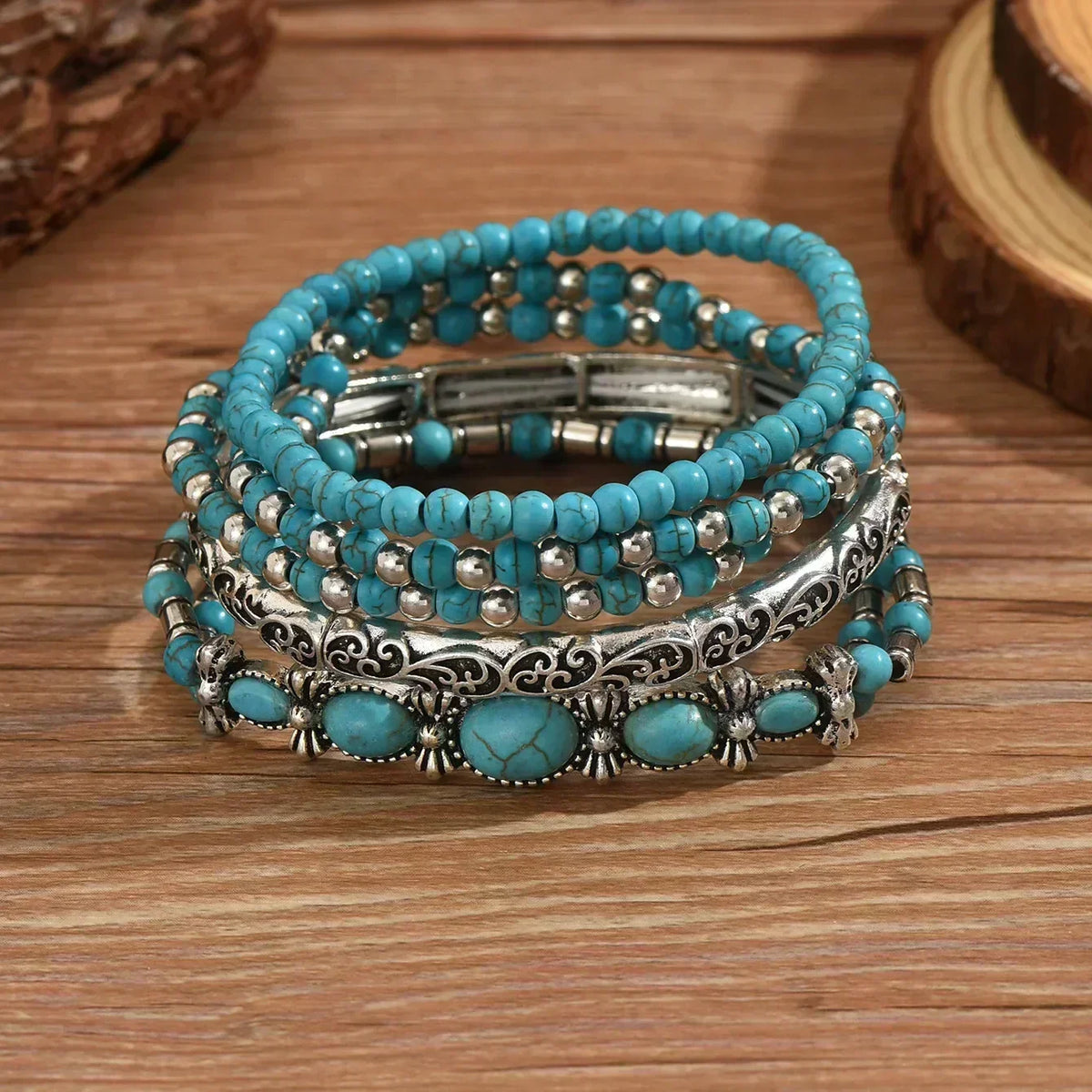 Set van 5 armbanden met turquoise kralen en zilverkleurige details.